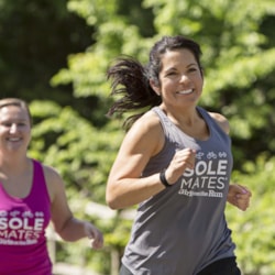 A Girls on the Run SoleMate smiling to someone off camera while working out